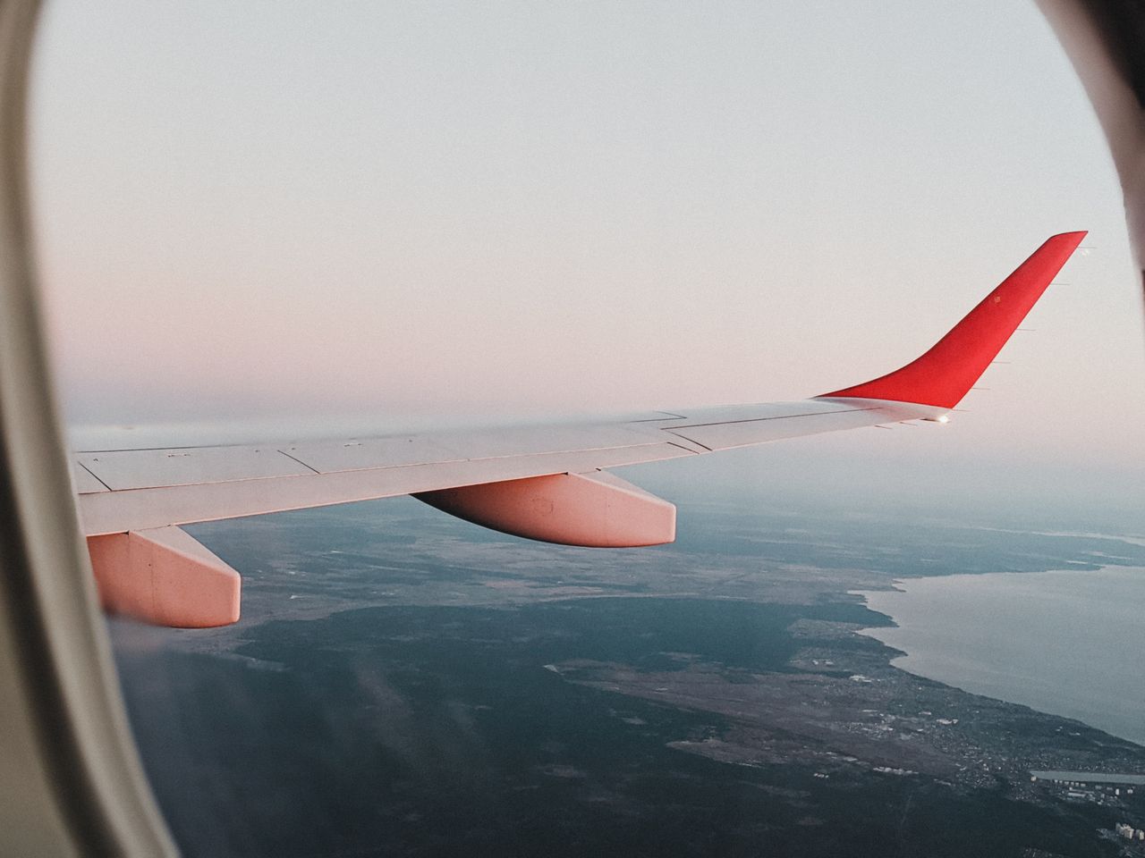 team-01 View from airplane window showing landscape of Vienna with sunset sky.