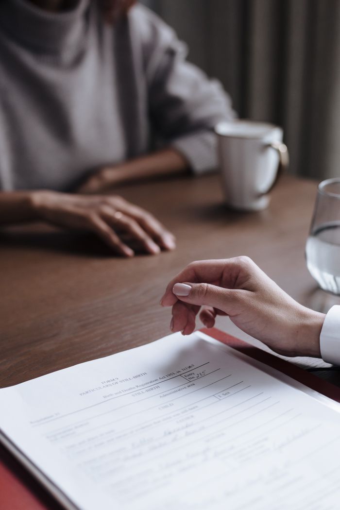 services-02 Two people in a business meeting reviewing and signing a contract.